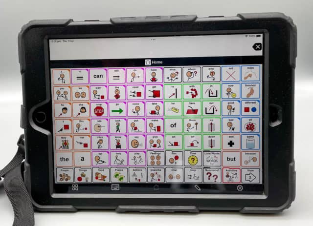 An iPad with a communication app displaying a grid with symbols and text. The communication app is called LAMP.