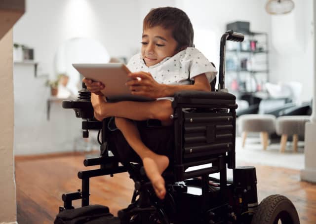 Young man in a wheelchair looking at a tablet